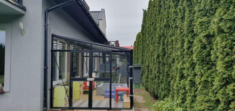 Widok z zewnątrz na zadaszoną strefę zabaw przy budynku pensjonatu